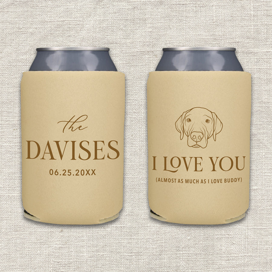 Two personalized beer can coolers shown side by side on a textured light beige fabric background. The left can cooler is camel with brown text featuring the couples' last name and wedding date. The right can cooler is camel with brown text and features a portrait of their dog and the words "I love you almost as much as I love the dog."