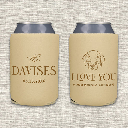Two personalized beer can coolers shown side by side on a textured light beige fabric background. The left can cooler is camel with brown text featuring the couples' last name and wedding date. The right can cooler is camel with brown text and features a portrait of their dog and the words "I love you almost as much as I love the dog."
